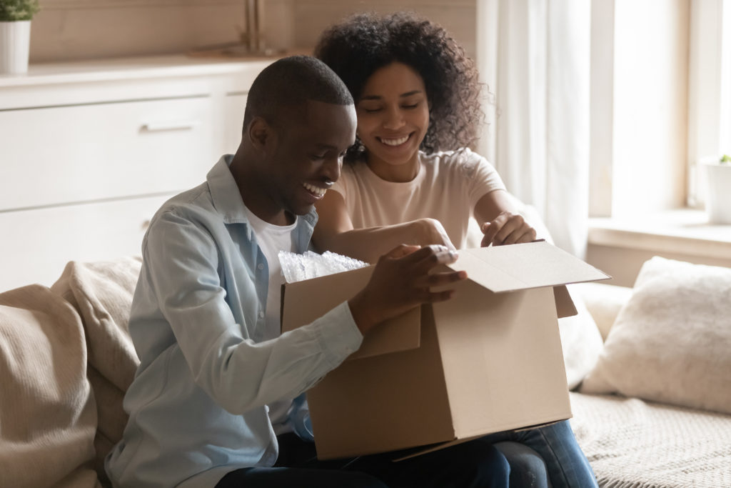 Excited couple unpack delivery box