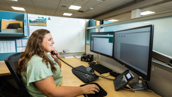 Women on the phone in office communicating with customer to hear concerns and create specialized solutions.