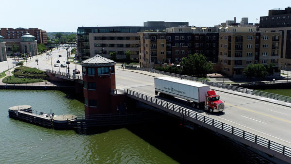 Truck driving across downtown bridge, serving quality products to customers in our community with our just-in-time delivery.