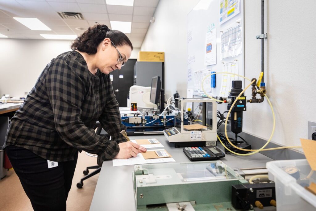 Female GBP employee working in an ISTA certified lab to ensure corrugated box quality.