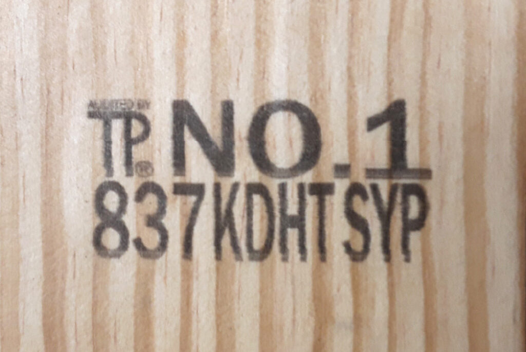 Close up to a piece of lumber with an identification code.