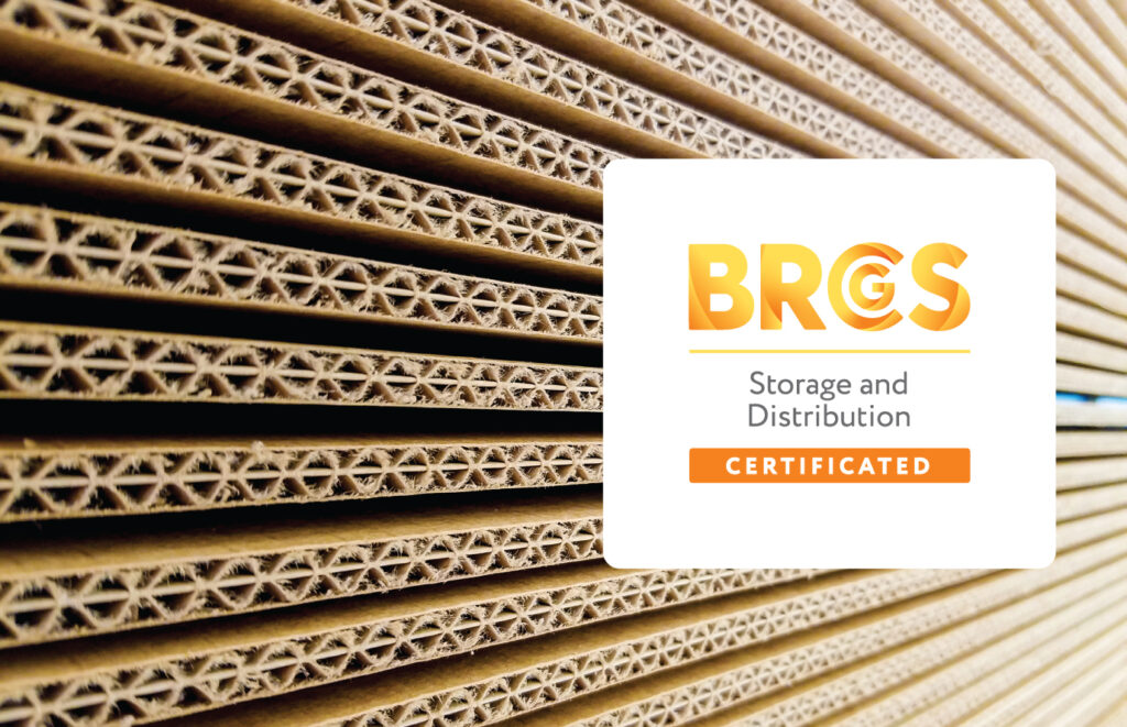 BRCGS Storage and Distribution certification logo behind a stack of corrugated sheets.